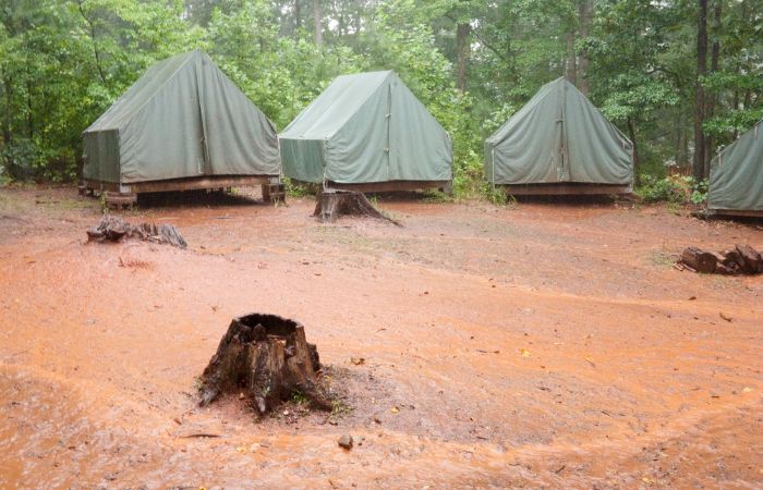 A group of tents set up in a muddy and flooded area