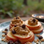 Healthy Campfire Apple Nachos with peanut butter, chocolate chips, and granola served in the great outdoors.